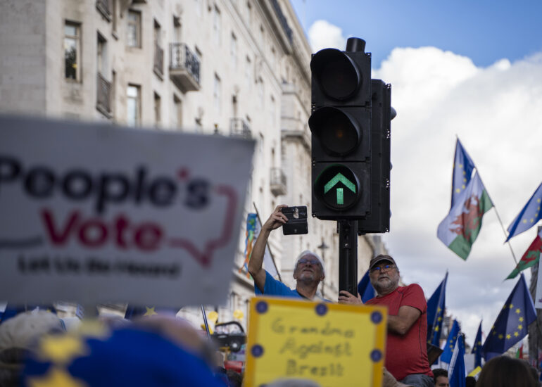 Personas subidas a un semáforo en la manifestación 'People's Vote